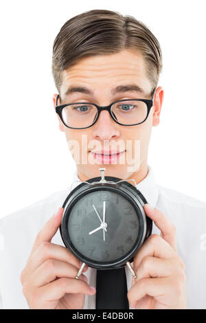 Geeky businessman holding alarm clock Stock Photo