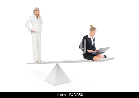 White scales measuring two businesswomen Stock Photo