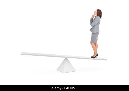Composite image of focused businesswoman on scales Stock Photo