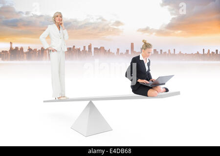 White scales weighing two businesswomen Stock Photo