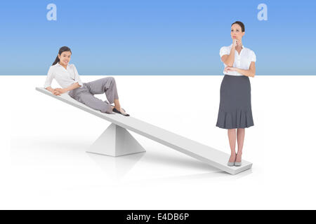 White scales weighing two businesswomen Stock Photo