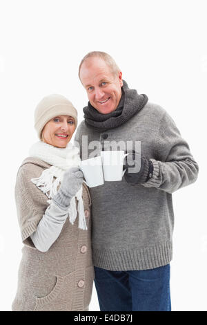Happy mature couple in winter clothes holding mugs Stock Photo
