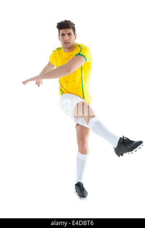 Football player in yellow jersey kicking Stock Photo