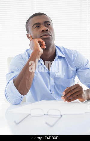 Thoughtful businessman sitting at his desk Stock Photo
