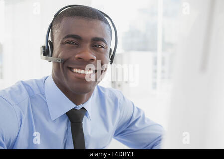 Happy businessman working at his desk wearing headset Stock Photo