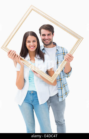 Happy young couple holding picture frame Stock Photo
