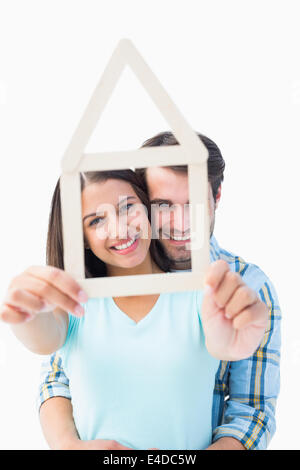 Happy young couple with house shape Stock Photo