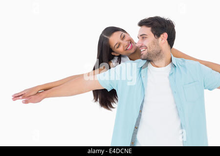 Happy casual man giving pretty girlfriend piggy back Stock Photo