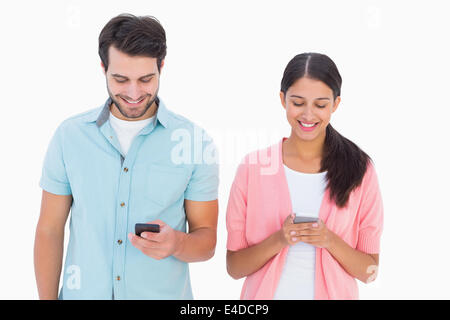 Happy couple sending text messages Stock Photo