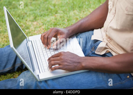 Man relaxing in his garden using laptop Stock Photo