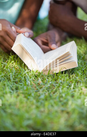 Young couple reading book on the grass Stock Photo