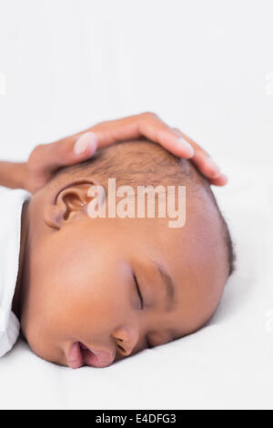 Adorable baby boy sleeping with fathers hand on head Stock Photo