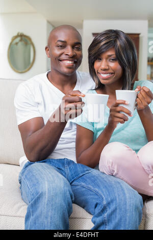 Happy couple relaxing on the couch having coffee Stock Photo