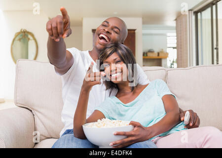 Happy couple relaxing on the couch watching tv Stock Photo