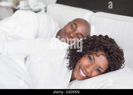Happy couple lying in bed together Stock Photo