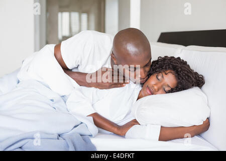 Happy couple lying in bed together Stock Photo