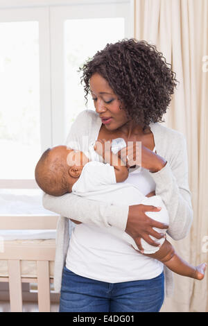 Happy mother feeding her baby boy his bottle Stock Photo