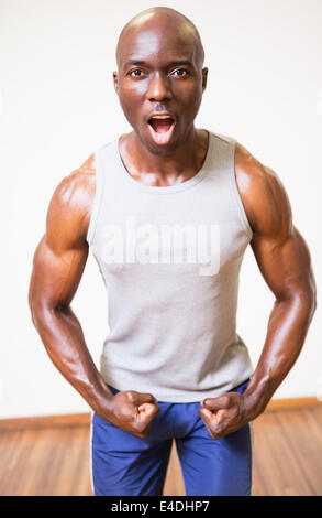 Muscular man shouting while flexing muscles Stock Photo