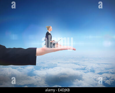 Composite image of businesswoman using laptop Stock Photo