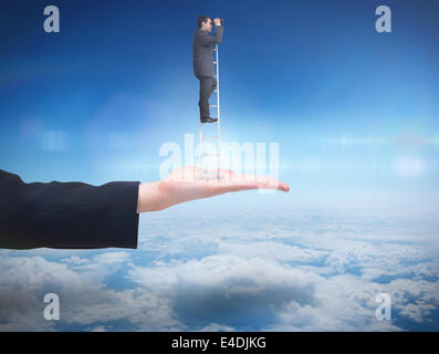 Composite image of businessman standing on ladder Stock Photo