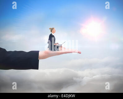 Composite image of businesswoman using laptop Stock Photo