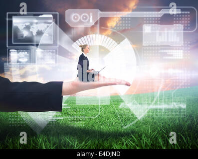 Composite image of businesswoman using laptop Stock Photo