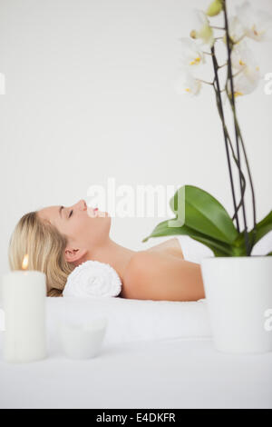 Beautiful blonde lying on massage table with salt scrub treatment at