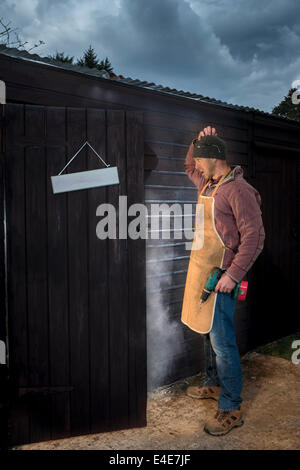 Man wondering what went wrong in his workshop. Stock Photo