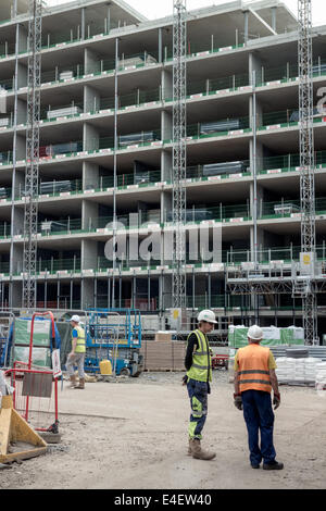 Tow construction workers / builders stood talking on a construction site Edinburgh's Quartermile district Stock Photo