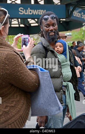 A mother taking a photo of her husband and young son in Union Square Park in Manhattan, New York City Stock Photo