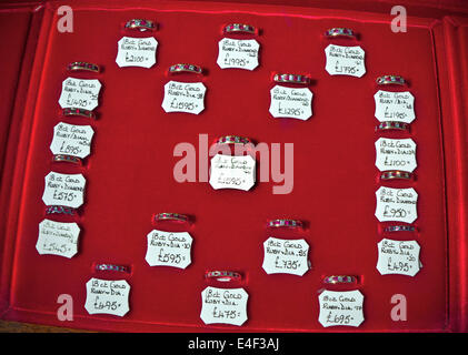 Eternity and engagement rings on display in jeweler's shop window with ticket prices in pounds sterling Stock Photo