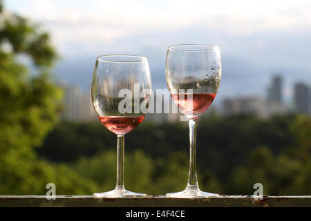 Two glasses of rose wine on a rusty railing Stock Photo