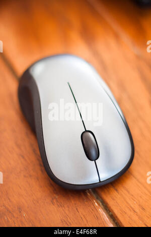 Silver wireless mouse on wood table Stock Photo