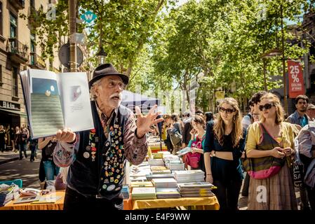 Barcelona, Spain. 23rd Apr, 2014. A bookseller entertains the visitors as they pass by his book stand on St Jordi in the Ramblas of Barcelona - Thousands of citizens and tourists fill the streets of the of Barcelona's city center to stroll between hundred of book and rose stands to celebrate Sant Jordi (St George's Day), Catalonia's patron saint, in a festive manner. © Matthias Oesterle/ZUMA Wire/ZUMAPRESS.com/Alamy Live News Stock Photo