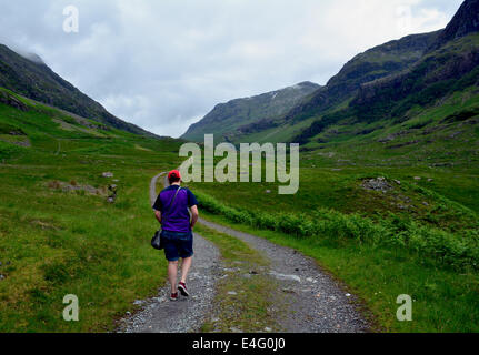 A young woman walking along a track in Glencoe, Scotland. Stock Photo