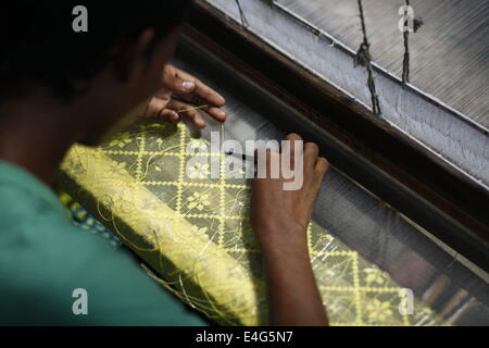 July 10, 2014 - Weavers weave famous Jamdani Saree.A sharee is the traditional garment worn by women in the Indian subcontinent. It is a long strip of unstitched cloth, ranging from five to nine yards in length, which can be draped in various style. The most common style is for the sari to be wrapped around the waist, with one end then draped over the shoulder.The Sharee boasts of the oldest existence in the world. It is more than 5,000 years old! Some people think that sharee is influenced by Greek or Roman toga, which we see on ancient statues. Stock Photo