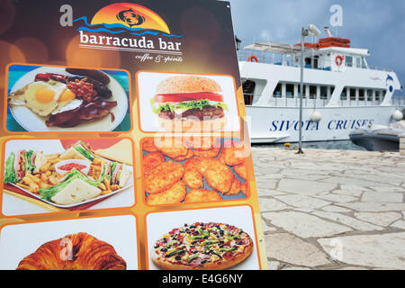 A menu board outside a seafront restaurant in Sivota, Greece. Stock Photo