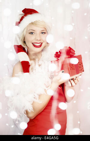 Young woman in Santa Claus costume holding gift box Stock Photo