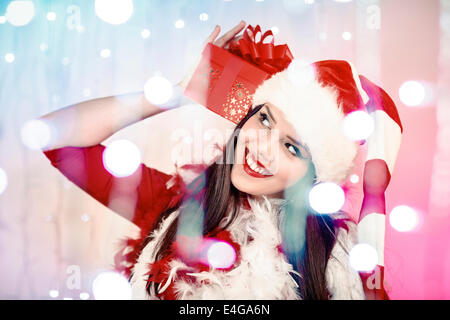 Young woman in Santa Claus costume holding gift box Stock Photo