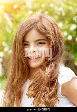 Portrait of smiling cute little girl having fun outdoors, playing in summer park, enjoying summer holidays, happiness concept Stock Photo