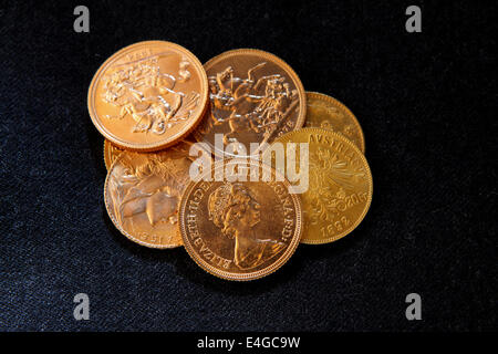 A pile of gold coins with British Sovereigns a French Napoleon (20 Franc piece) and an Austrian 8 Florin/20 Francs piece. Stock Photo