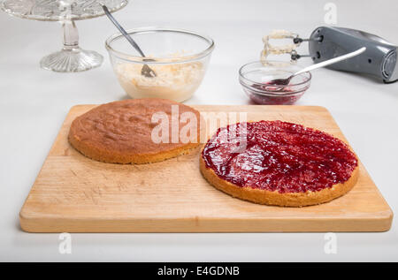 a victoria sponge cake sliced, jam spread,ready for butter cream  [Land] 'making a cake' (28 of 44) Stock Photo