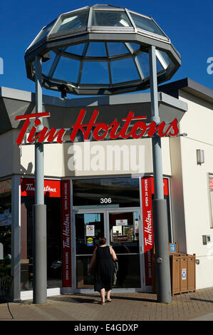 Woman entering a Tim Hortons coffee shop and restaurant in Vancouver, BC, Canada Stock Photo