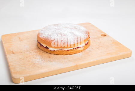 victoria sponge cake Filled with jam and butter cream sprinkled with icing sugar on a wooden board  "cut out" (38 of 44) Stock Photo