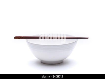 Empty noodle bowl with chopsticks on top isolated on white background Stock Photo