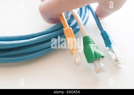 Hand holding network cables one white background Stock Photo