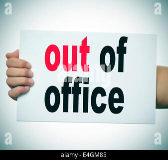 man hand and arm holding a signboard with the text out of office written in it Stock Photo