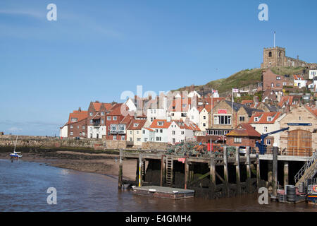 View of Whitby harbour and sea wall, with the church on the hill in the background. Stock Photo