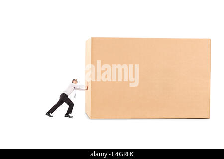 Determined businessman pushing a huge box Stock Photo
