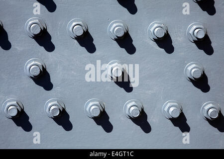 Old silver grey cast iron metal background with rivets of nuts and bolts Stock Photo